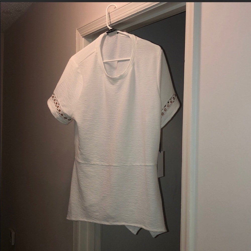 White blouse with gold accents.